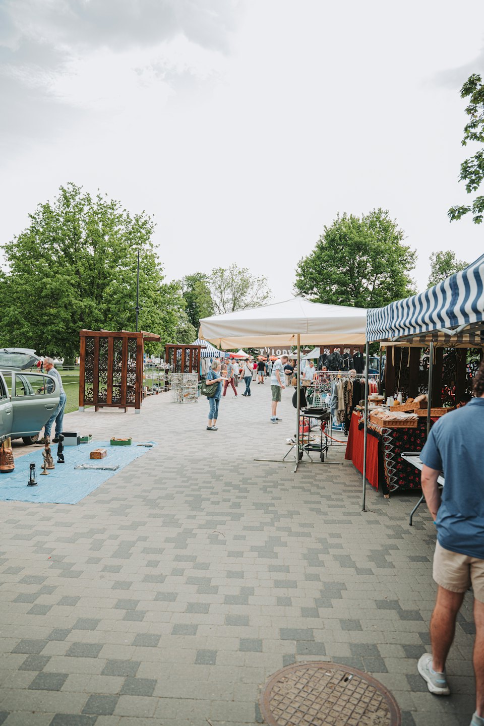 People browse stalls at a bustling outdoor market.