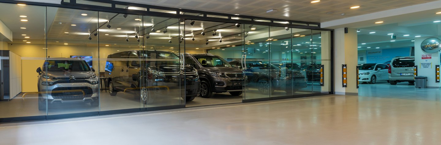 New cars displayed inside a modern car dealership showroom.