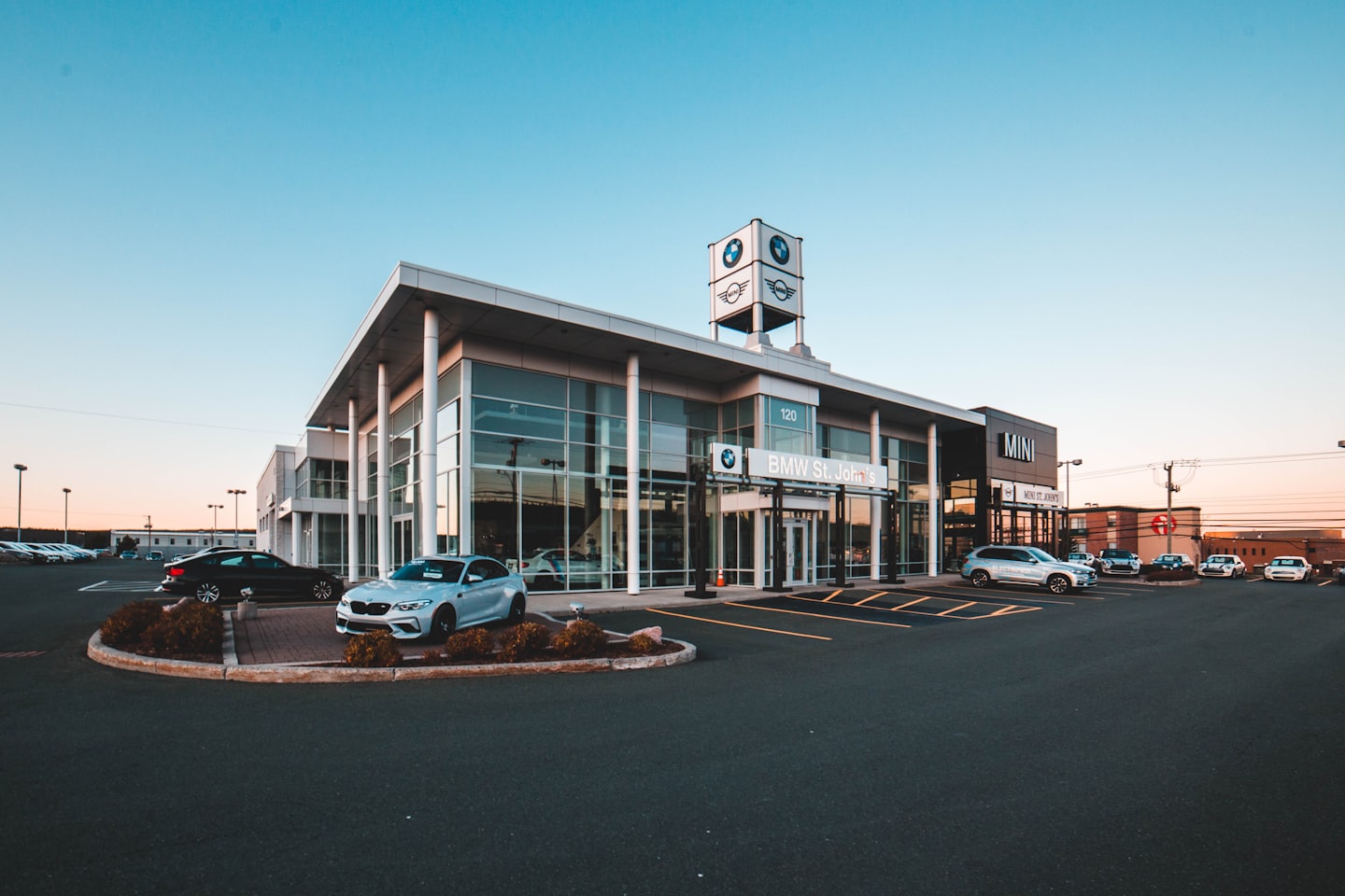 Modern car dealership with luxury vehicles displayed outside.